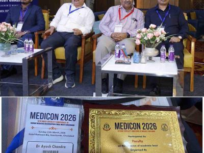 Four men in business attire seated on stage at MEDICON 2026, with lanyard badges, flowers, and water bottles on glass tables in a conference setting.